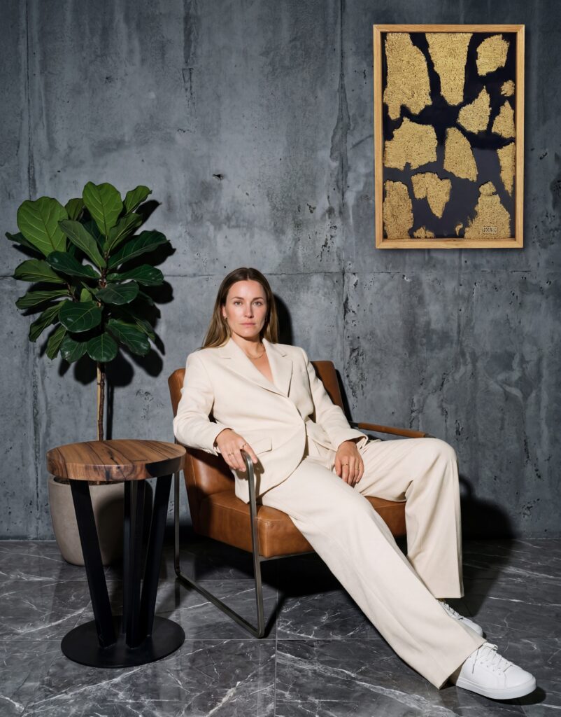 Kobieta prezentująca obraz z żywicy epoksydowej i stolik z drewna Opari Design